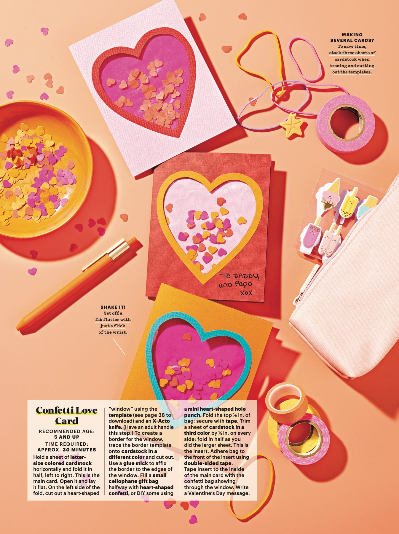 A collection of papercraft gift cards with heart-shaped cutout, sit against a peach-coloured background, surrounded by stationery and craft supplies. 